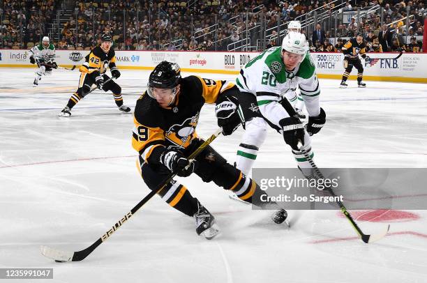Evan Rodrigues of the Pittsburgh Penguins skates in front of the defense of Ryan Suter of the Dallas Stars at PPG PAINTS Arena on October 19, 2021 in...