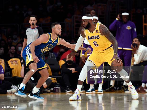 LeBron James of the Los Angeles Lakers controls the ball against Stephen Curry of the Golden State Warriors during the first half of a basketball...