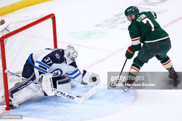 Connor Hellebuyck of the Winnipeg Jets makes a save on a shot by Nico Sturm of the Minnesota Wild during the third period at Xcel Energy Center on...