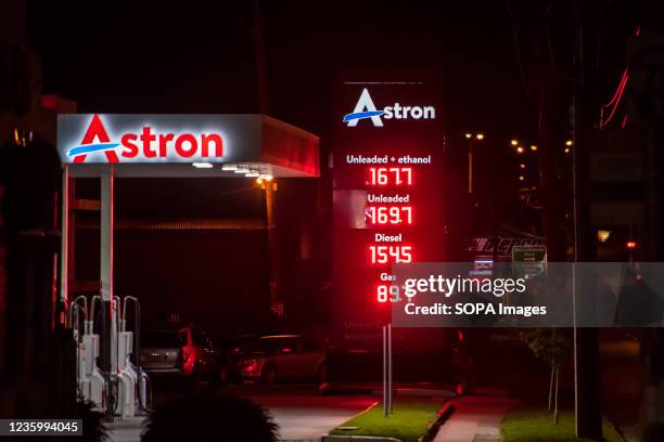 Aston petrol station in Australia at night with a price display showing record high fuel prices.