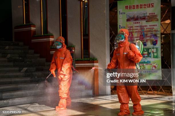 Employees spray disinfectant as part of preventative measures against the Covid-19 coronavirus at the Yokjon Department Store in Pyongyang on October...