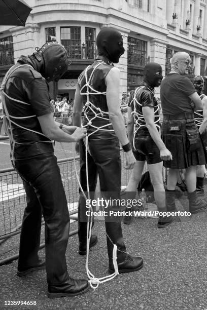 Rope-bound fetishists wearing black leather and masks during the Gay Pride Parade in London on 4th July 2009.