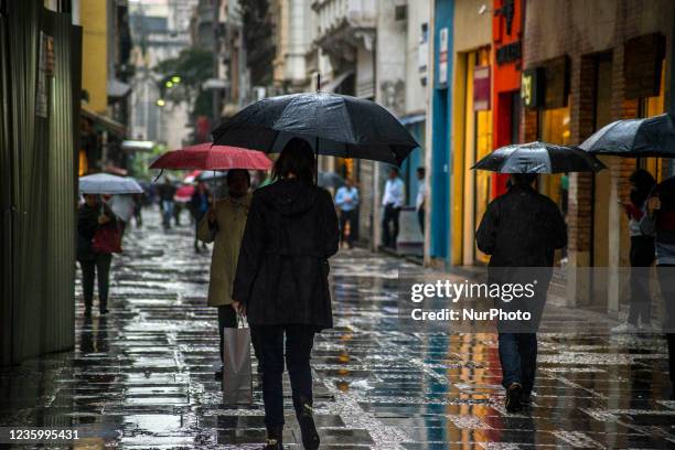 Pedestrians face drizzle in downtown Sao Paulo, Brazil, on Otober 19, 2021.