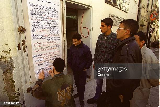 Un militant du parti islamiste algérien du Mouvement de la société pour la paix , placarde, le 21 février 2000 à Constantine, un tract opposé à la...