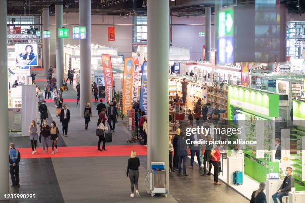 October 2021, Hessen, Frankfurt/Main: Visitors walk through Hall 3.0 on the first day for trade visitors at the Frankfurt Book Fair 2021. After the...