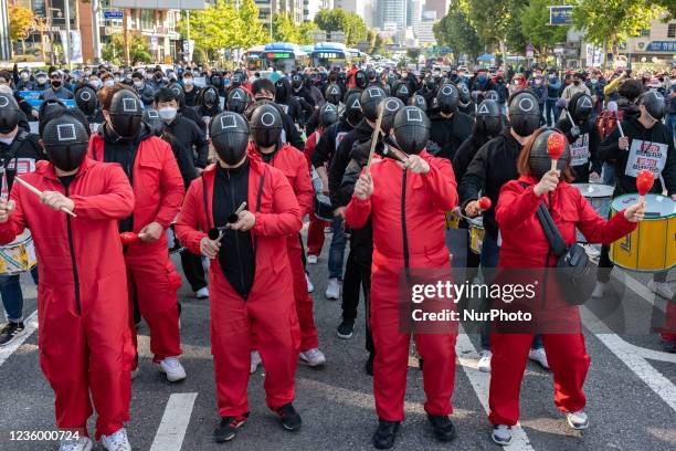 Members of the Korean Confederation of Trade Unions wear masks costumed in the Netflix series Squid Game for a march to Seoul City hall during a...