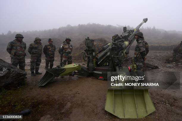 Indian Army soldiers stand next to a M777 Ultra Lightweight Howitzer positioned at Penga Teng Tso ahead of Tawang, near the Line of Actual Control ,...