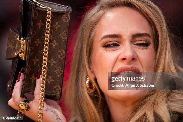 Los Angeles, CA Singer Adele uses her purse to hide from the TV camera while she sings along to her song being played to the audience while attending...