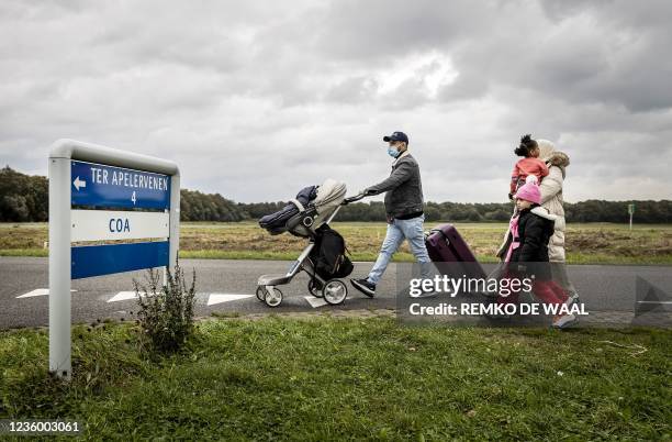 Newly arrived asylum seekers walk on their way to the overcrowded application center for asylum seekers in the Groningen village of Ter Apel as the...