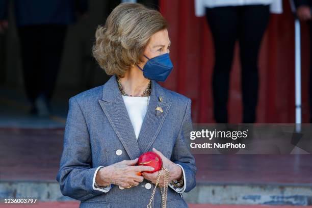 Queen Sofia with a pomegranate and a persimmon in her hands during her visit the Food Bank of Granada on October 20, 2021 in Granada, Spain.