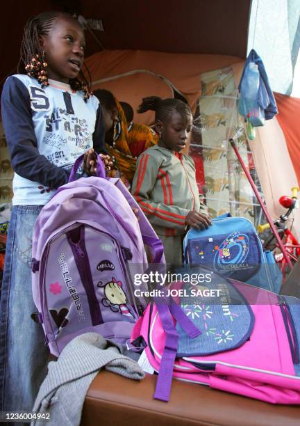 Les enfants de Dioh Camara, Assita , neuf ans, et Kané , sept ans, préparent leur cartable pour aller à l'école primaire Babeuf, le 02 septembre 2005...