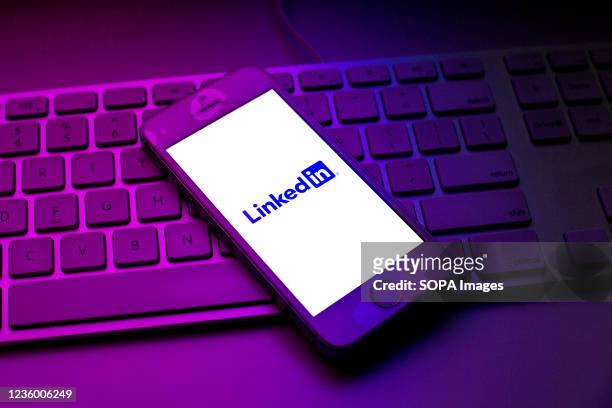 In this photo illustration a LinkedIn logo seen displayed on a smartphone on top of a computer keyboard.