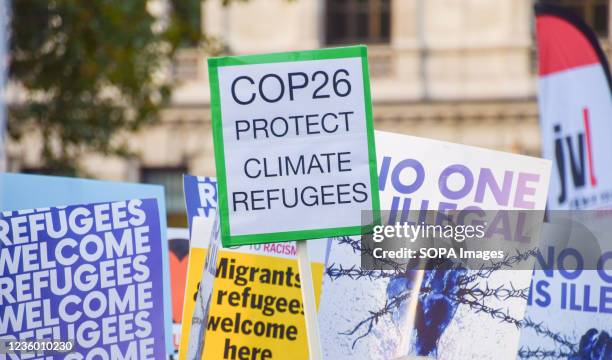 Placard calling on COP26 to protect climate refugees is seen during the Refugees Welcome rally. Demonstrators gathered in Parliament Square in...