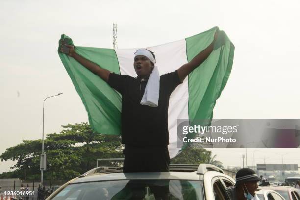 Man carries a Nigerian national flag during a protest to commemorate one year anniversary of #EndSars, a protest against a military attack on...