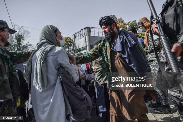 Taliban members stop women protesting for women's rights in Kabul on October 21, 2021. - The Taliban violently cracked down on media coverage of a...