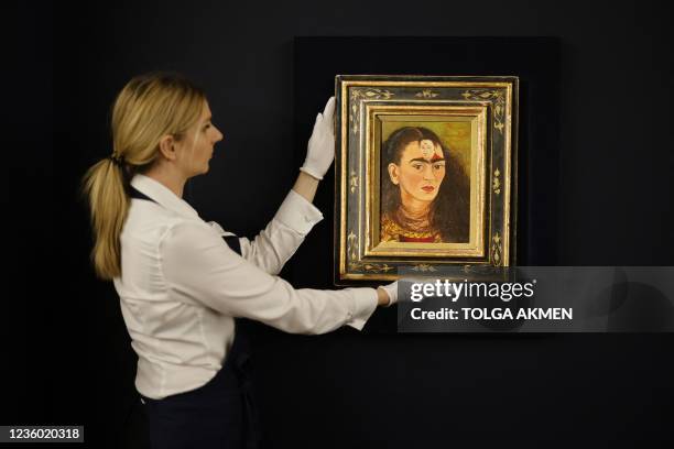 An assistant displays the artwork entitled Diego y yo by Mexican painter Frida Kahlo at Sotheby's auction house in central London on October 21,...