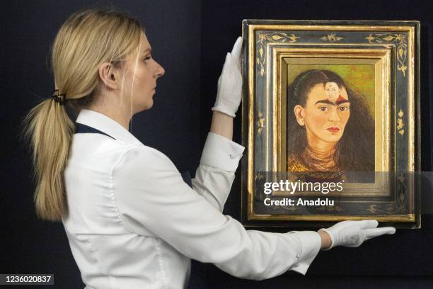 Sotheby's staff member holds a painting titled Diego y yo by artist Frida Kahlo in London, United Kingdom on October 21, 2021. The double portrait...