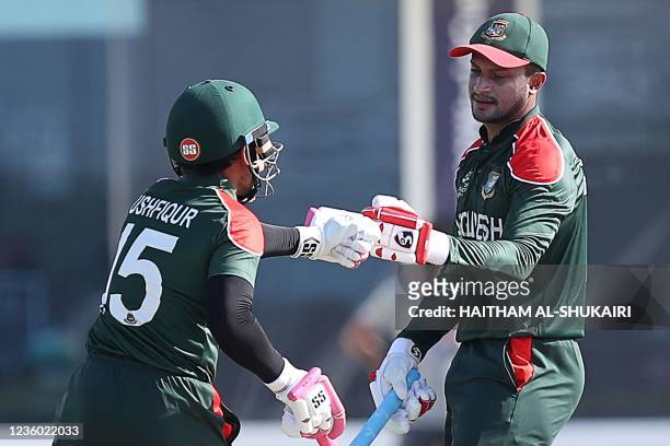 Bangladesh's wicketkeeper Mushfiqur Rahim bumps his fist with teammate Shakib Al Hasan during the ICC men's Twenty20 World Cup cricket match between...