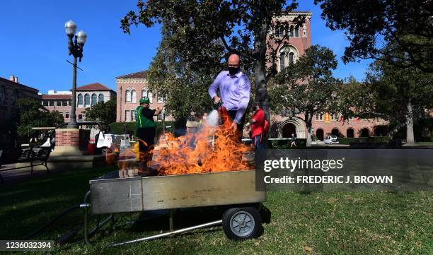 Phil Turner from USC Auxillary Services uses a fire extinguisher to put out a fire during the annual Great California Shakeout earthquake disaster...