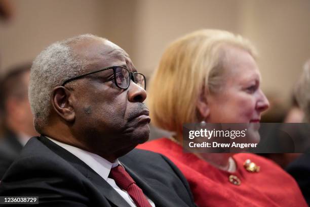 Associate Supreme Court Justice Clarence Thomas sits with his wife and conservative activist Virginia Thomas while he waits to speak at the Heritage...