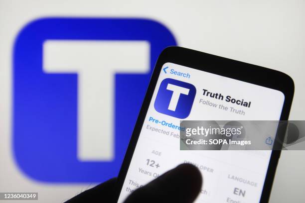 In this photo illustration, Truth Social logo of a social networking platform is seen displayed on a smartphone, with a background of Facebook and...