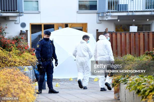 Police officer and forensics work on a crime scene at the Hammarby Sjostad district in Stockholm on October 22, 2021 after a person believed to be...