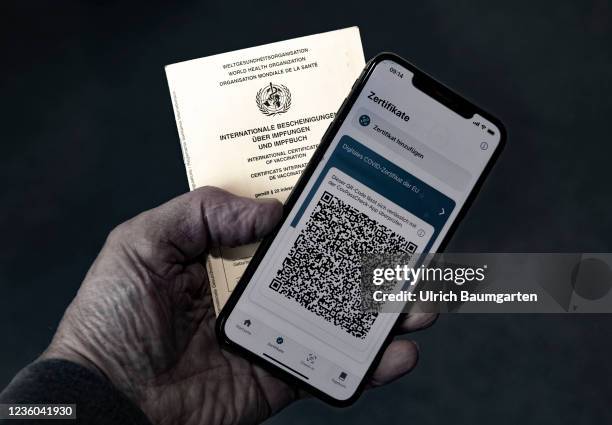 This photo illustration shows the display of a mobile phone with a Covid-19 vaccination certificate and an international vaccination pass. Photo on...