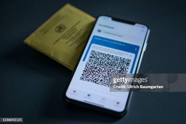 This photo illustration shows the display of a mobile phone with a Covid-19 vaccination certificate and an international vaccination pass. Photo on...