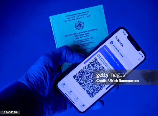 This photo illustration shows the display of a mobile phone with a Covid-19 vaccination certificate and an international vaccination pass. Photo on...