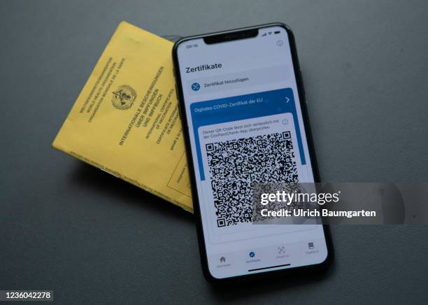 This photo illustration shows the display of a mobile phone with a Covid-19 vaccination certificate and an international vaccination pass. Photo on...