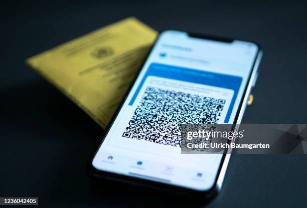 This photo illustration shows the display of a mobile phone with a Covid-19 vaccination certificate and an international vaccination pass. Photo on...