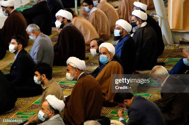 Mask-clad Iranians Iranian Shiite Muslim clerics gather in a mosque in the capital Tehran to perform the Friday prayers, for the first time after...