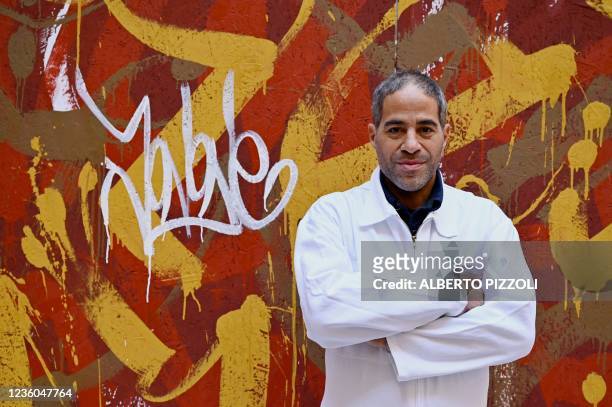 Street artist Artist JonOne, known for a abstract expressionist-styled graffiti, poses by his piece "Cippo 2.0" on October 20, 2021 at Palazzo...
