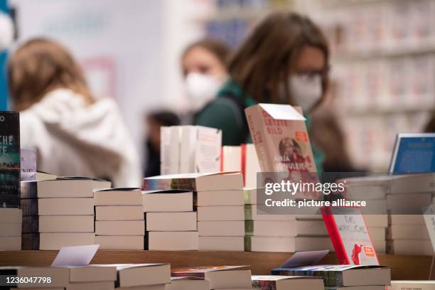 October 2021, Hessen, Frankfurt/Main: Visitors stand in the dtv Verlag stand during the first visitor day of the Frankfurt Book Fair 2021. After a...