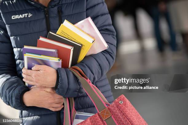 October 2021, Hessen, Frankfurt/Main: A woman holds books during the first visitor day of the Frankfurt Book Fair 2021. After a pandemic-induced fair...