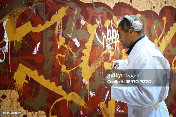 Street artist Artist JonOne, known for a abstract expressionist-styled graffiti, works on his piece "Cippo 2.0" on October 20, 2021 at Palazzo...