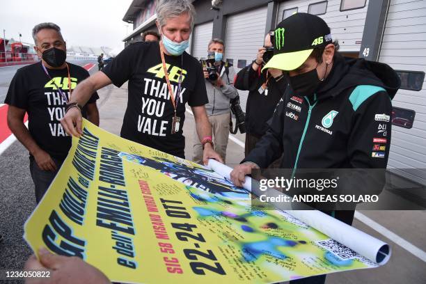 Italian motorcycle road racer and multiple time MotoGP World Champion Valentino Rossi receives from reporters a poster signed by members of the...