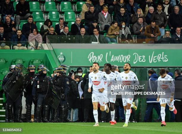 Angers' football players return to the field after AS Saint-Etienne supporters launched smoke canisters to protest against the last place of their...