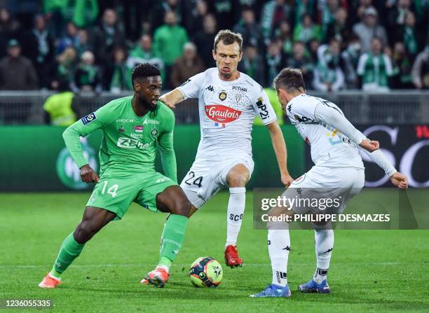 Saint-Etienne's French forward Jean-Philippe Krasso challenges Angers' French defender Romain Thomas and Angers' French midfielder Pierrick Capelle...