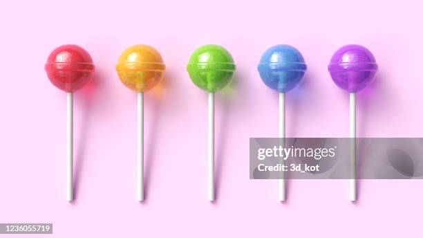Set of five colorful sweet lollipops on pink pastel background