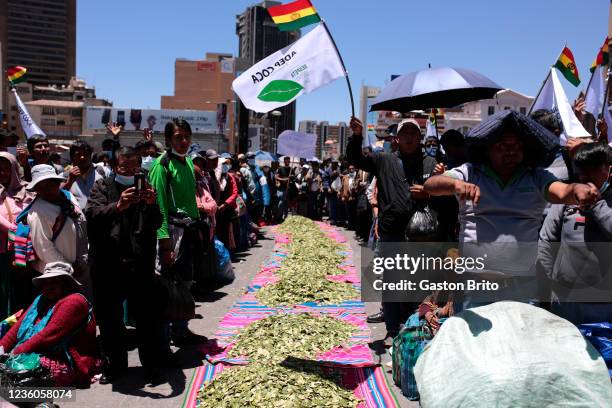 People stand next to a way with coca leaves during the celebration of the day of 'Acullico' at Plaza de San Francisco on October 22, 2021 in La Paz,...