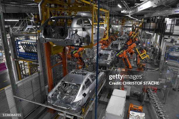 Robots work on cars at an assembly line in the main company of Germany's carmaker BMW in Munich, southern Germany, on October 22, 2021.