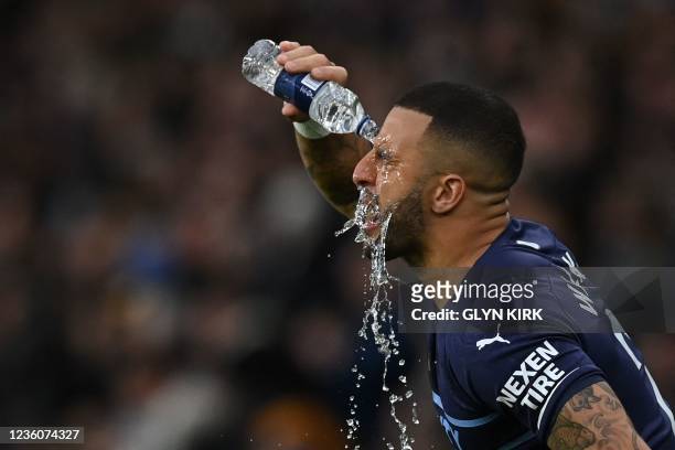 Manchester City's English defender Kyle Walker pours water on his face as he prepares to start the English Premier League football match between...