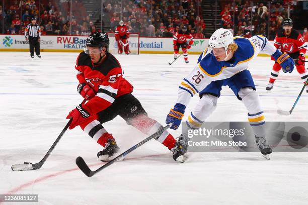 Jesper Bratt of the New Jersey Devils plays the puck against Rasmus Dahlin of the Buffalo Sabres at Prudential Center on October 23, 2021 in Newark,...