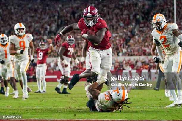 Brian Robinson Jr. #4 of the Alabama Crimson Tide is hit by Jeremy Banks of the Tennessee Volunteers as he scores a touchdown in the fourth quarter...