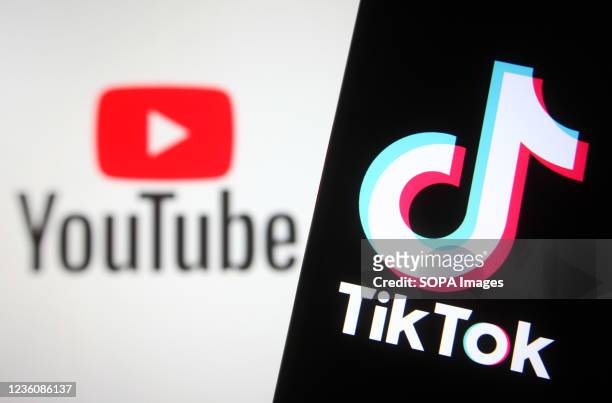 In this photo illustration a TikTok logo is seen on a smartphone screen with a YouTube logo of an online video sharing and social media platform in...