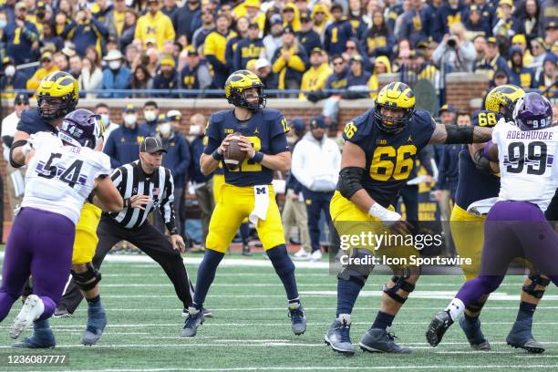 Michigan Wolverines quarterback Cade McNamara looks for a receiver while Michigan Wolverines offensive lineman Chuck Filiaga blocks during a B1G 10...