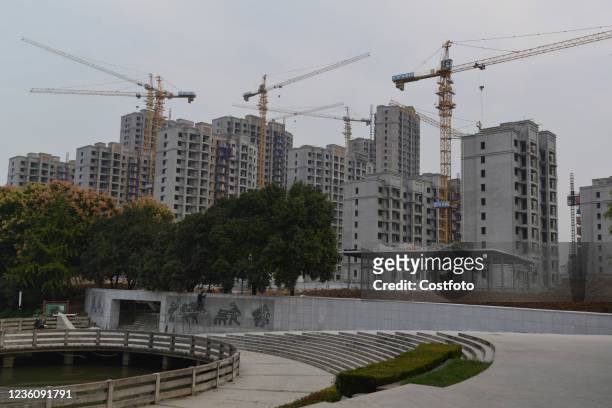 Worker works near a residential and commercial building under construction in Fuyang, East China's Anhui province, Oct 24, 2021. Real estate tax...
