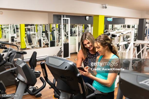 personal trainer and client using a fitness app - peloton app stock pictures, royalty-free photos & images