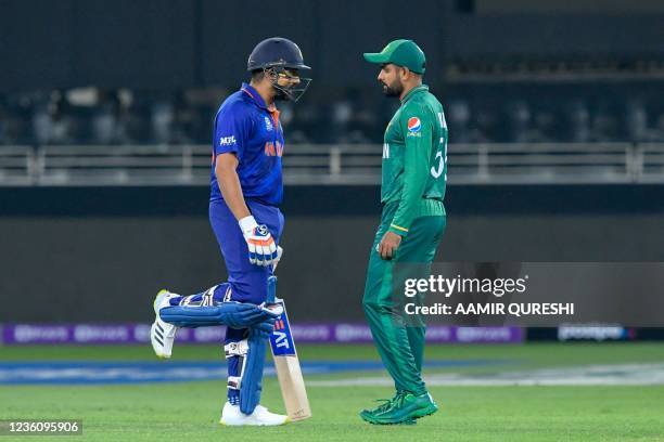 India's Rohit Sharma walks past Pakistan's captain Babar Azam as he arrives to bat during the ICC mens Twenty20 World Cup cricket match between India...